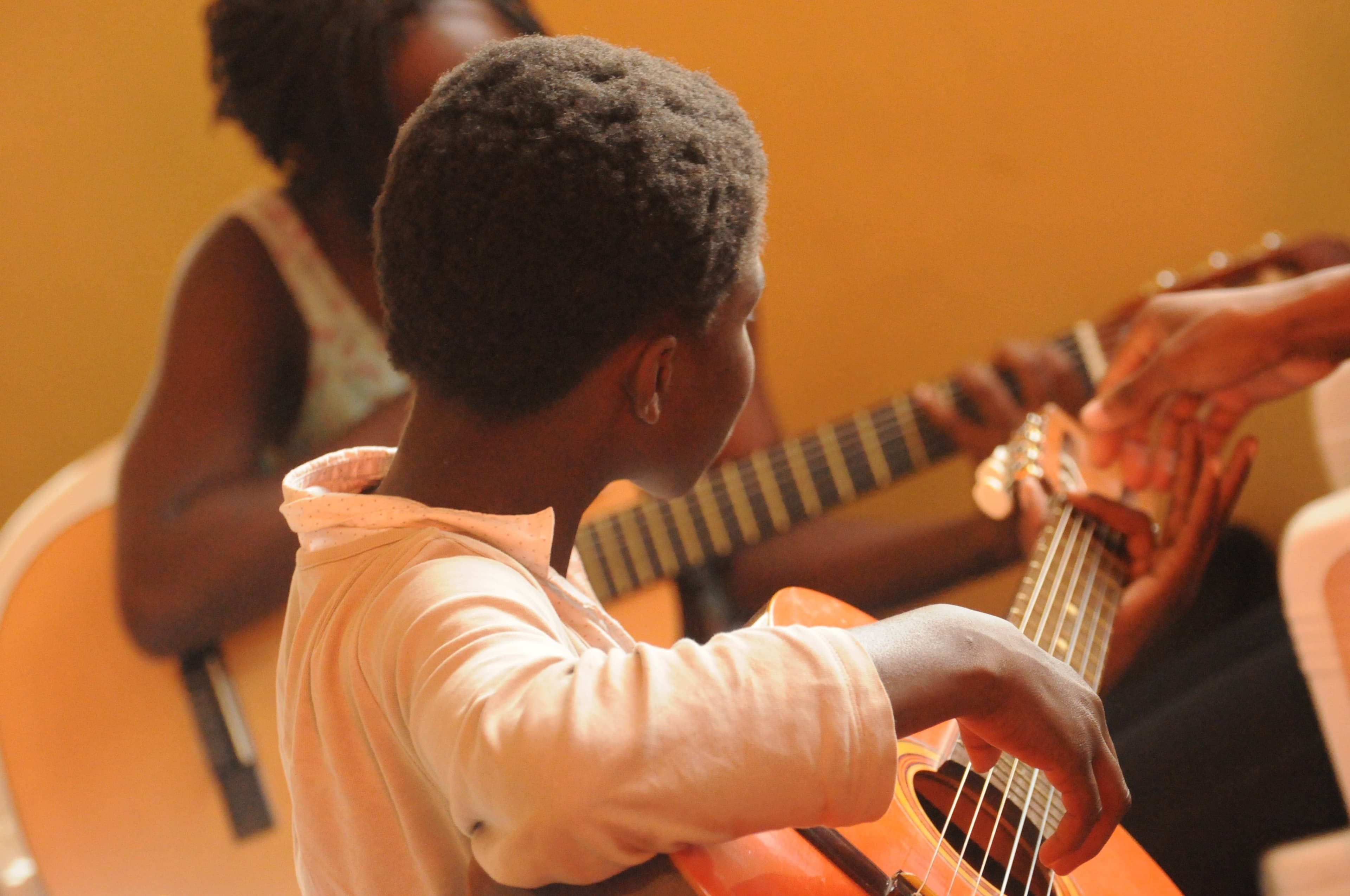 A child learning to play the guitar